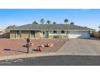 Charming single-story home featuring desert landscaping, a gray roof, and a two-car garage at 1057 S 74Th St, Mesa, AZ 85208