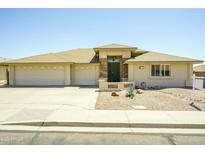 Charming single-story home featuring a three-car garage and desert landscaping for low maintenance appeal at 11447 E Mendoza Ave, Mesa, AZ 85209