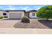 Charming home showcasing a well-maintained front yard with desert landscaping and a two-car garage at 2229 N Middlecoff Dr, Mesa, AZ 85215