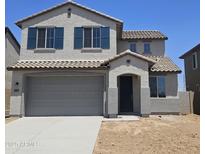 Charming two-story home featuring a gray exterior, gray garage door, and a beautifully tiled roof at 22392 W Monona Ln, Surprise, AZ 85387