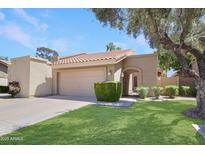 Charming single-story home featuring a well-manicured lawn, mature trees, and a tile roof at 2663 N Carriage Ln, Chandler, AZ 85224