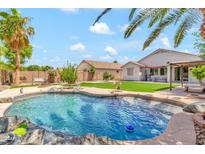 Inviting backyard oasis featuring a sparkling pool, lush landscaping, and a relaxing patio area at 3044 E Sparrow Pl, Chandler, AZ 85286