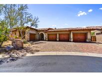Charming home featuring a four-car garage, desert landscaping, and brick paved driveway at 4050 N Terra Mesa Cir, Mesa, AZ 85207