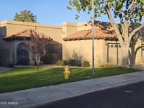 Charming, single-story home with well-maintained lawn, desert landscaping, and a quaint, red tile roof at 4116 E Lupine Ave, Phoenix, AZ 85028