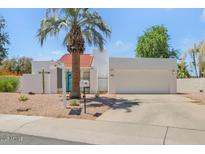 Charming single-story home featuring a white exterior, a vibrant blue front door and well-maintained landscaping at 511 E Calavar Rd, Phoenix, AZ 85022