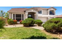 Charming home featuring a well-manicured lawn, lush bushes, and vibrant floral accents at 5322 N Oro Vista Ct, Litchfield Park, AZ 85340