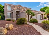 Charming two-story home featuring a desert landscape, curved walkway, and a three car garage at 1377 W Park Ave, Gilbert, AZ 85233