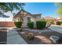 Charming home featuring a stone facade, manicured bushes, and a well-maintained yard at 15272 W Georgia Dr, Surprise, AZ 85379