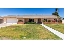 Charming single-story home with a well-manicured lawn and colorful landscaping at 2330 E Elmwood St, Mesa, AZ 85213