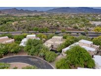 Scenic aerial view showcases the property's lush landscaping and the stunning mountain backdrop at 39016 N Habitat Cir, Cave Creek, AZ 85331