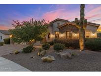 Charming home exterior with desert landscaping and a stone facade at dusk at 5512 E Barwick Dr, Cave Creek, AZ 85331