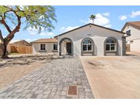 Charming single-story home with painted brick, arched windows, and a well-manicured paver driveway at 6332 W Sunnyslope Ln, Glendale, AZ 85302