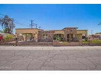 Charming home featuring beautiful stonework, a gated yard, and a covered parking area at 6459 W Columbus Ave, Phoenix, AZ 85033