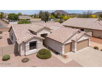 Beige single-story home featuring a tile roof, desert landscaping, and a two-car garage at 6988 W Monte Lindo --, Glendale, AZ 85310