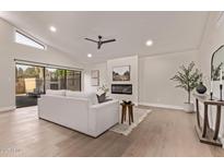Bright living room featuring a fireplace, high ceilings, and sliding glass doors to the backyard at 7962 E San Miguel Ave, Scottsdale, AZ 85250