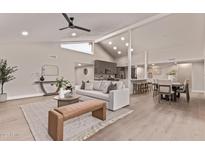 Open-concept living room featuring a fireplace, high ceilings, and seamless flow into the dining area at 7962 E San Miguel Ave, Scottsdale, AZ 85250