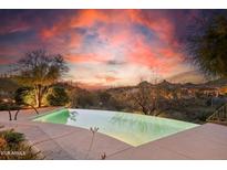 An infinity pool overlooking a scenic landscape with a vibrant sunset at 11334 E Troon Vista Dr, Scottsdale, AZ 85255