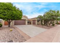 Charming single-story home with a three-car garage, desert landscaping, and a gated courtyard entry at 12906 W Oyer Ln, Peoria, AZ 85383
