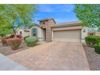 Charming home with a stone accents, desert landscaping and a brick paver driveway at 134 E Bernie Ln, Gilbert, AZ 85295
