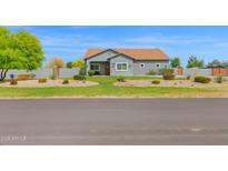 Charming single-story home features a desert landscape, lush lawn and a welcoming facade at 14415 N 184Th Ave, Surprise, AZ 85388