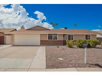 Charming single-story home featuring a two-car garage, desert landscaping, and a blue sky backdrop at 1713 W Palomino Dr, Chandler, AZ 85224