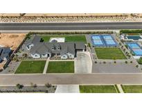 Expansive aerial view of a modern single-story home complete with private tennis and pickleball courts at 18826 E Augusta Ave, Queen Creek, AZ 85142