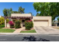 Charming home featuring a well-maintained front yard, colorful landscaping, and a two-car garage, enhancing curb appeal at 2322 S Rogers -- # 1, Mesa, AZ 85202
