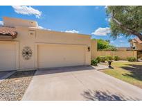Beige single-Gathering home with a two-car garage, desert landscaping, and lovely curb appeal at 2369 W Shawnee Dr, Chandler, AZ 85224