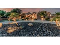 Beautiful desert home featuring manicured landscaping with rock features and an inviting, curved driveway at 3754 E Flintlock Dr, Queen Creek, AZ 85142