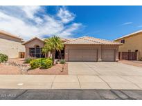 Charming single-story home with a three-car garage, desert landscaping, and a tile roof at 411 N Cordoba Pl, Chandler, AZ 85226