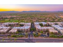 Stunning aerial view of condo community with golf course and mountain views at sunset, offering serene desert living at 5450 E Deer Valley Dr # 1195, Phoenix, AZ 85054