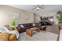 Inviting living room featuring a leather sectional sofa, stylish decor, and views into dining area and kitchen at 5450 E Deer Valley Dr # 1195, Phoenix, AZ 85054