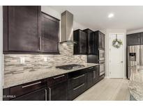 Gourmet kitchen with gas cooktop, granite counters, stainless steel appliances, and ample cabinet space at 7251 E Portobello Ave, Mesa, AZ 85212