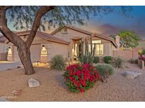 Charming single-story home featuring desert landscaping, a tile roof, and a welcoming facade at dusk at 10335 E Morning Star Dr, Scottsdale, AZ 85255