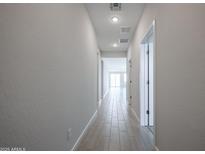 Bright hallway featuring tile flooring and neutral wall paint leading to the living area at 22035 N Rummler Ln, Maricopa, AZ 85138