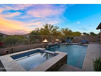 Sparkling pool and hot tub area with fire bowls and desert scenery at 24042 N 170Th Ln, Surprise, AZ 85387