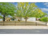 Charming home featuring desert landscaping with vibrant trees and a rustic fence at 2901 W Mandalay Ln, Phoenix, AZ 85053