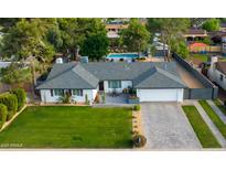 Aerial view of a charming home with a well-maintained yard, pool, and lush landscaping at 3027 W Wescott Dr, Phoenix, AZ 85027