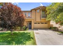 Charming two-story home featuring stone accents, a well-manicured lawn, and a welcoming entryway at 4355 E Cullumber St, Gilbert, AZ 85234