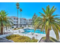 Inviting community pool with palm trees and lounge chairs at 4730 W Northern Ave # 1141, Glendale, AZ 85301