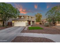 Beautiful two-story home with a well-manicured lawn, charming red door, and a spacious three-car garage at 5919 S Banning St, Gilbert, AZ 85298