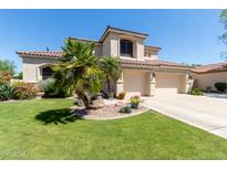Inviting home featuring a manicured lawn, desert landscaping and a three car garage at 7242 W Aurora Dr, Glendale, AZ 85308