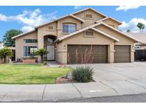 Inviting two-story home with a well-manicured lawn and a spacious three-car garage at 1215 W Wahalla W Ln, Phoenix, AZ 85027