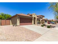 Lovely single-Gathering home showcasing a clay tile roof, desert landscaping, and a spacious three-car garage at 14208 W Larkspur Dr, Surprise, AZ 85379