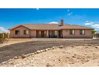 Charming single-story home featuring a well-manicured front yard and a welcoming entrance under a partly cloudy sky at 20041 W Colter St, Litchfield Park, AZ 85340