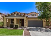 Charming two-story home featuring a gray two-car garage, solar panels, desert landscaping, and a covered porch at 20709 W Delaney Dr, Buckeye, AZ 85396