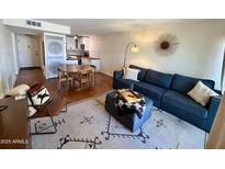 Cozy living room features a sectional sofa, stylish decor, and open layout to the kitchen and dining area at 3314 N 68Th St # 107, Scottsdale, AZ 85251