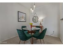 Bright dining area with a round glass table, velvet chairs, and modern pendant lighting at 3830 E Lakewood E Pkwy # 1007, Phoenix, AZ 85048