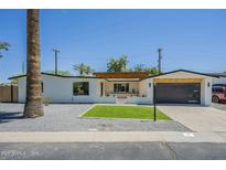 Modern home featuring neutral paint, desert landscaping and a dark finished garage door at 47 Spur Cir, Scottsdale, AZ 85251