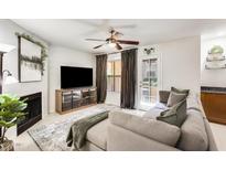 Bright living room with a neutral color palette, comfortable couch, and a cozy fireplace at 8787 E Mountain View Rd # 1029, Scottsdale, AZ 85258